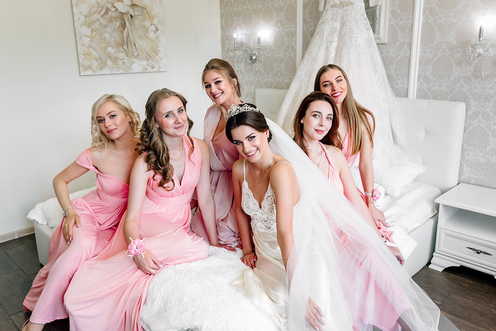 Подружки невесты в одинаковых платьях розового цвета.