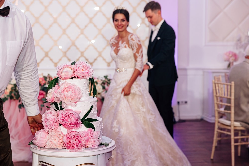 Белый свадебный торт с розовыми пионами.