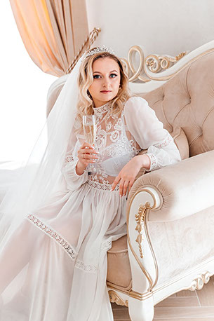 Невеста в шикарном кресле с бокалом шампанского.