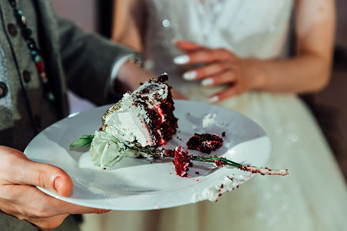 Сладкий кусочек свадебного торта на тарелке, отрезанный молодоженами вместе.